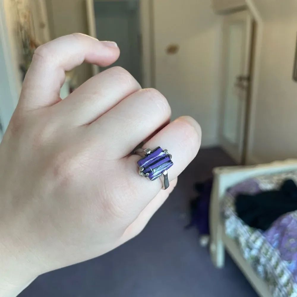 Silver colored ring with a purple stone